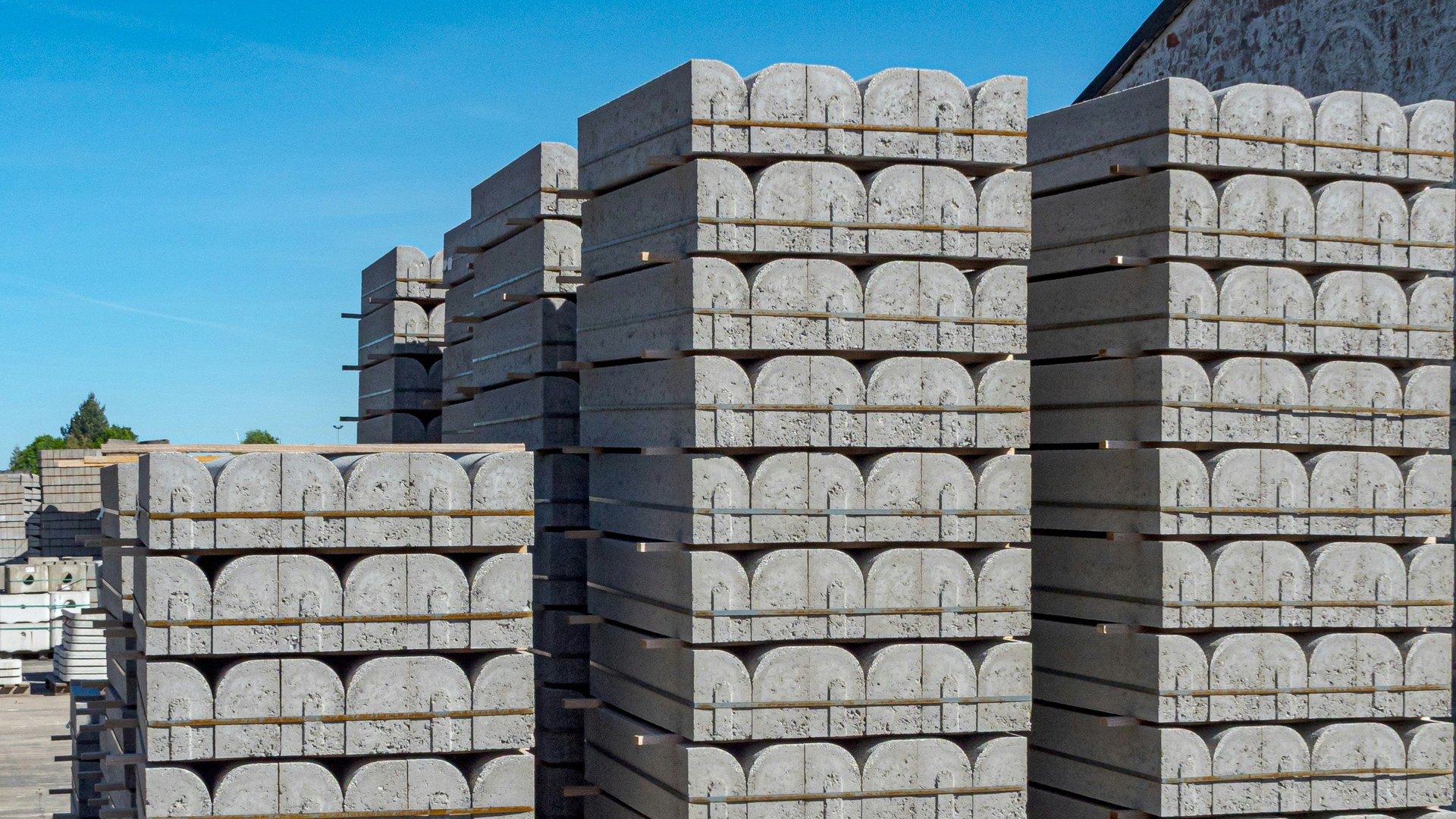 Tall stacks of precast concrete blocks in a yard, banded and layered so that only the outermost blocks can be reached.
