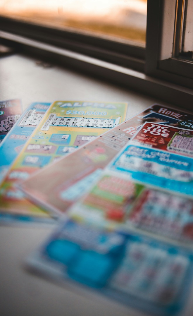 Several scratch lottery tickets fanned out on a windowsill.